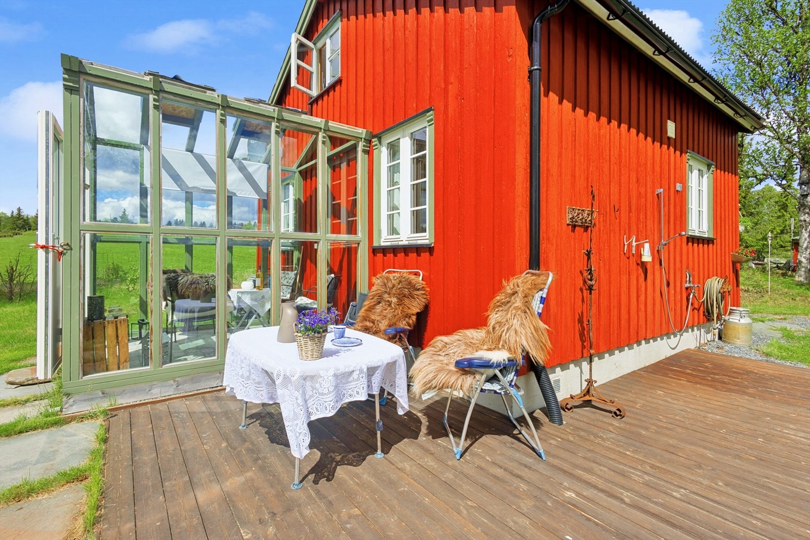 Terrasse/verandaareal binder sammen hytten og det innglassede drivhuset/utestuen. Dusj og frokost i solen til høyre, og soling med lunsj og middag til venstre. Galleribilde