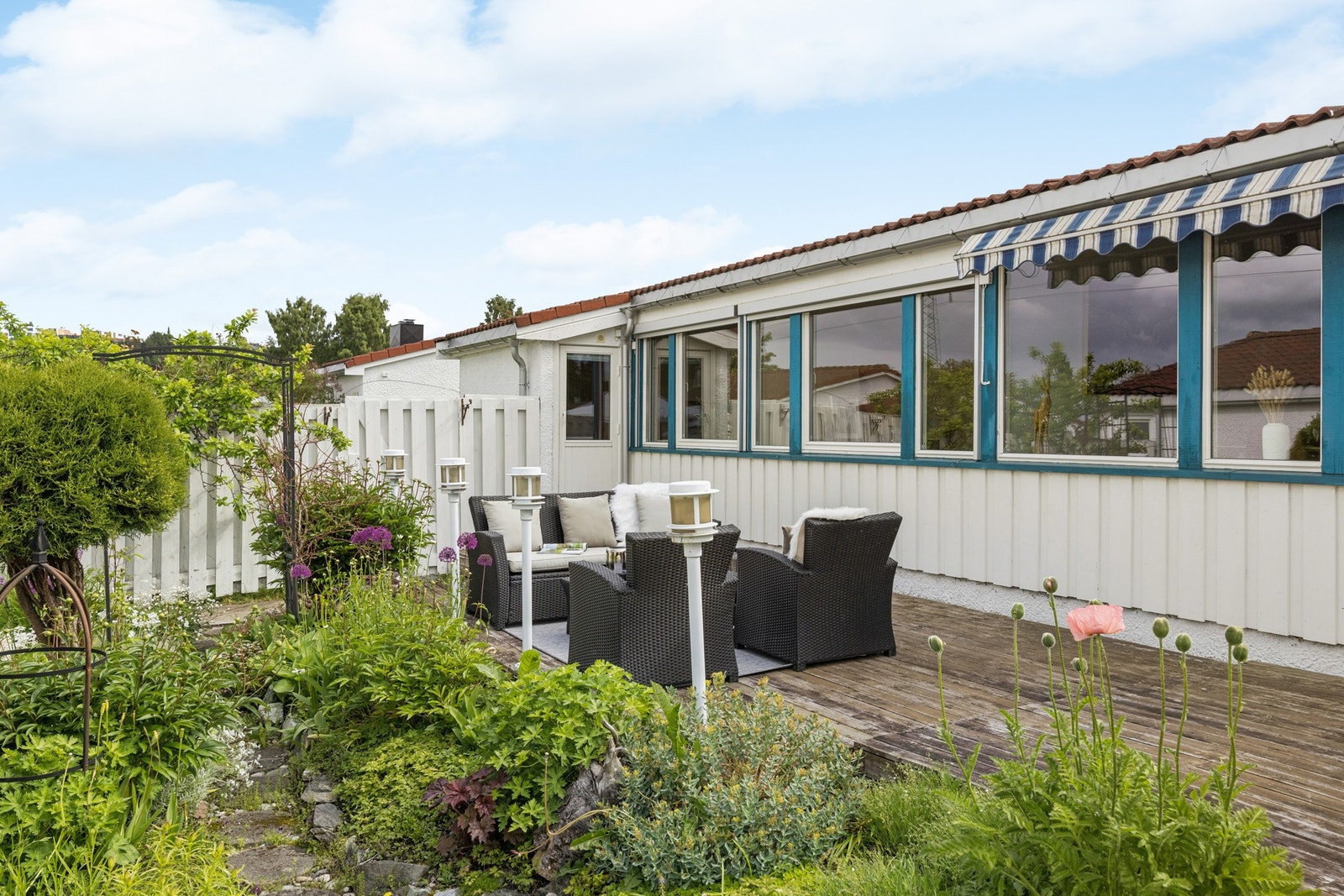 Terrassen ligger skjermet til omgitt av frodig beplantning og byr på en hyggelig ramme for avslappende sommerdager. Galleribilde