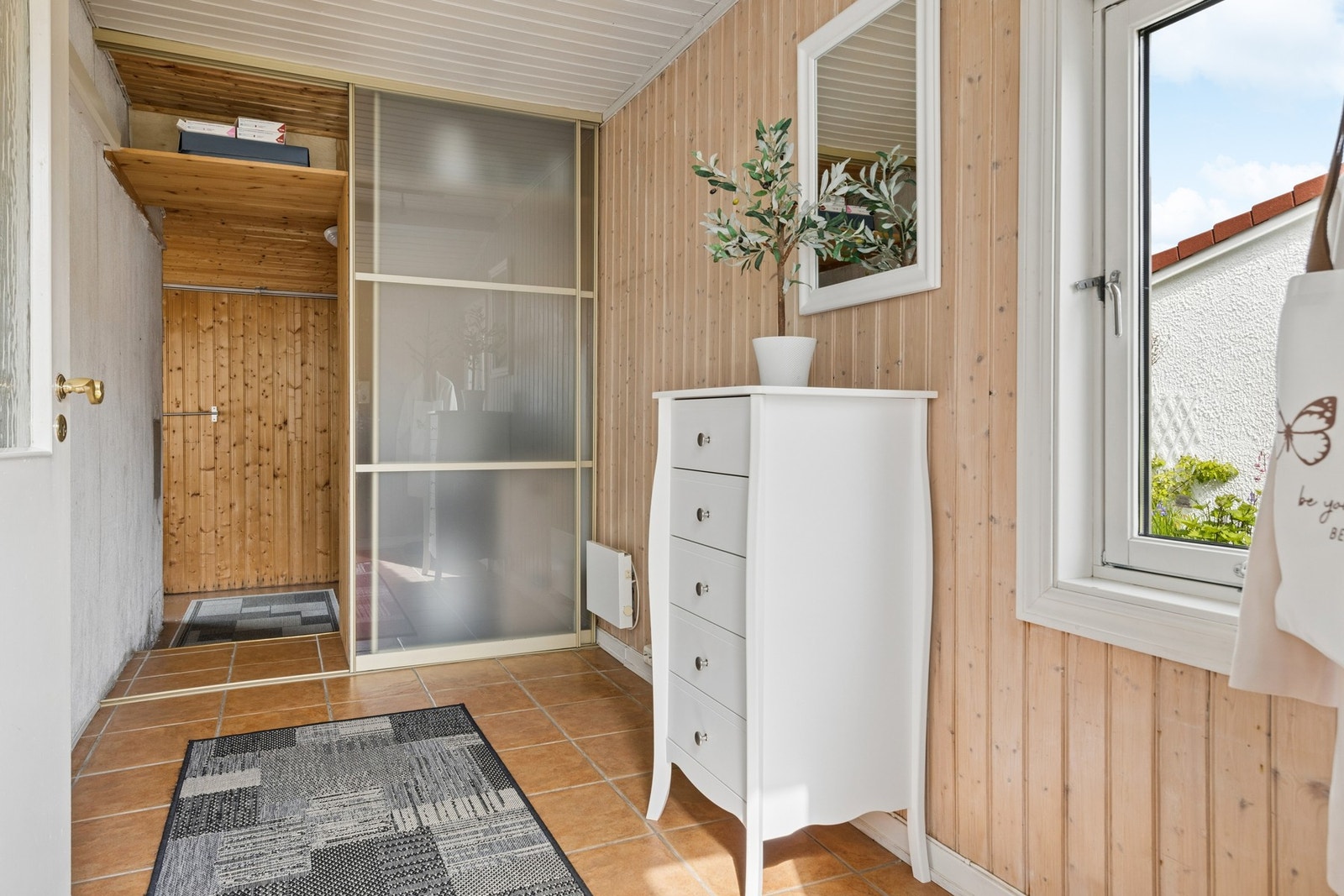 Lys og innbydende entré med flislagt gulv og gode oppbevaringsmuligheter. Galleribilde