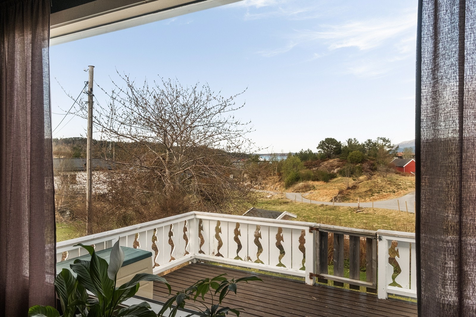 Terrasse med tregulv og utsikt over nærliggende landskap. Galleribilde