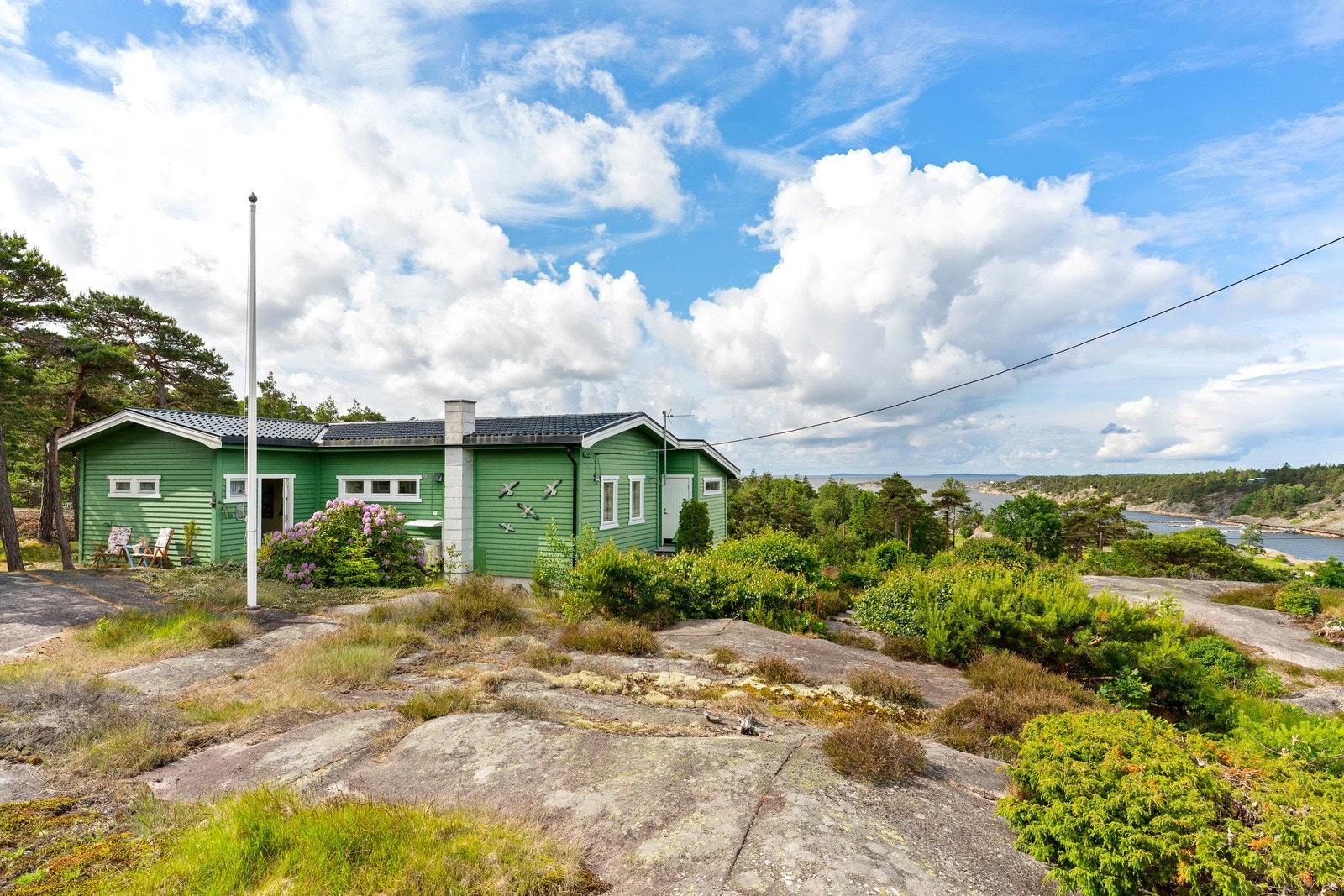 Eiendommen ligger åpent og solrikt til, med vakker natur rundt og sjøen som en flott del av bakteppet. Galleribilde