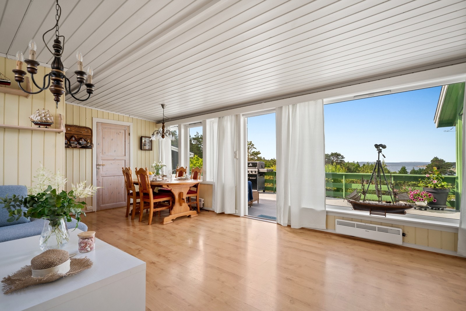 Store vindusflater gir stuen rikelig med dagslys og åpner opp mot terrassen og det flotte kystlandskapet. Galleribilde