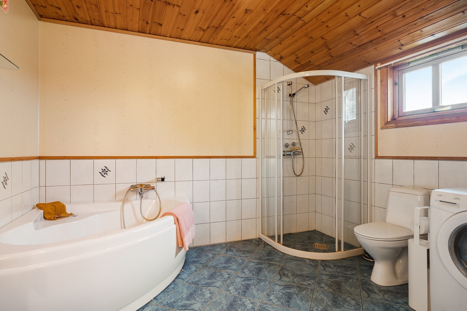 Badet i første etasje har flislagt gulv med varmekabler, badekar og dusjnisje. Galleribilde