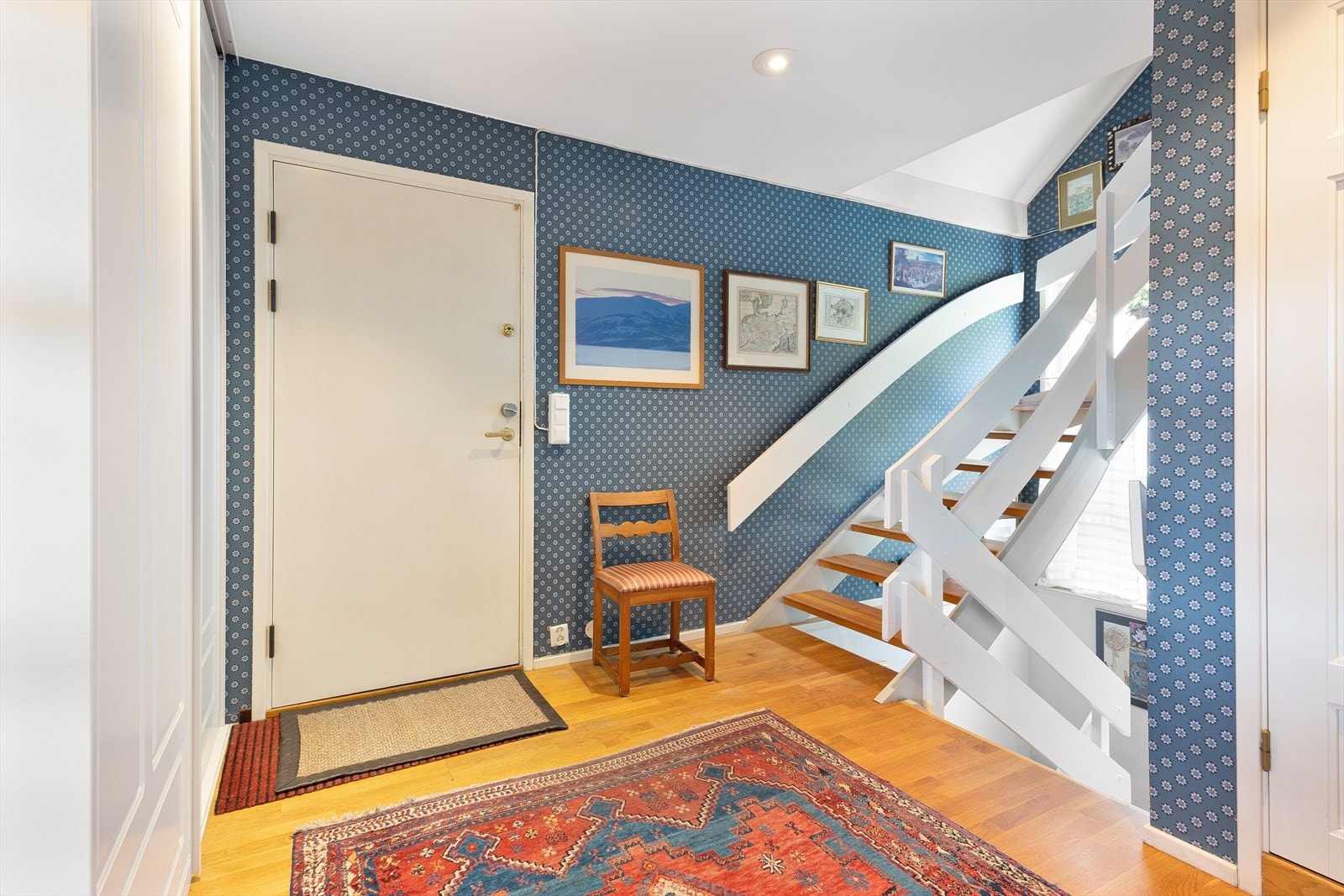 Entré med parkett på gulv og trappeforbindelse til boligens øvrige plan. Galleribilde