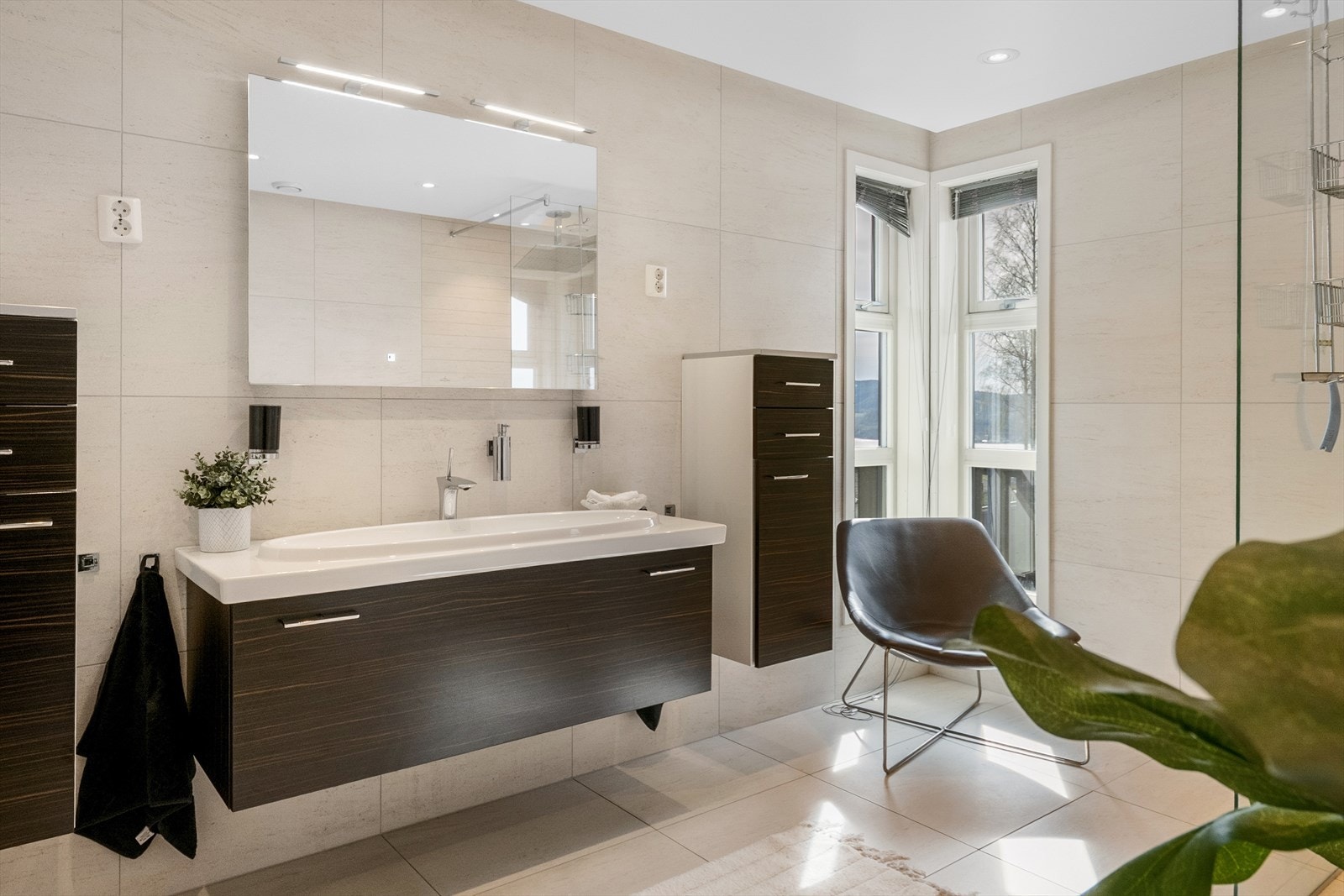 Det er fliser på gulv og vegger, samt malte plater med downlights i himling. Galleribilde