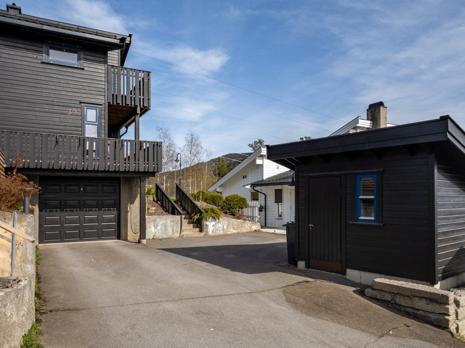 Gårdsplassen og innkjøringen er asfaltert, og det er hellelagte gangveier og støttemurer på eiendommen. Galleribilde