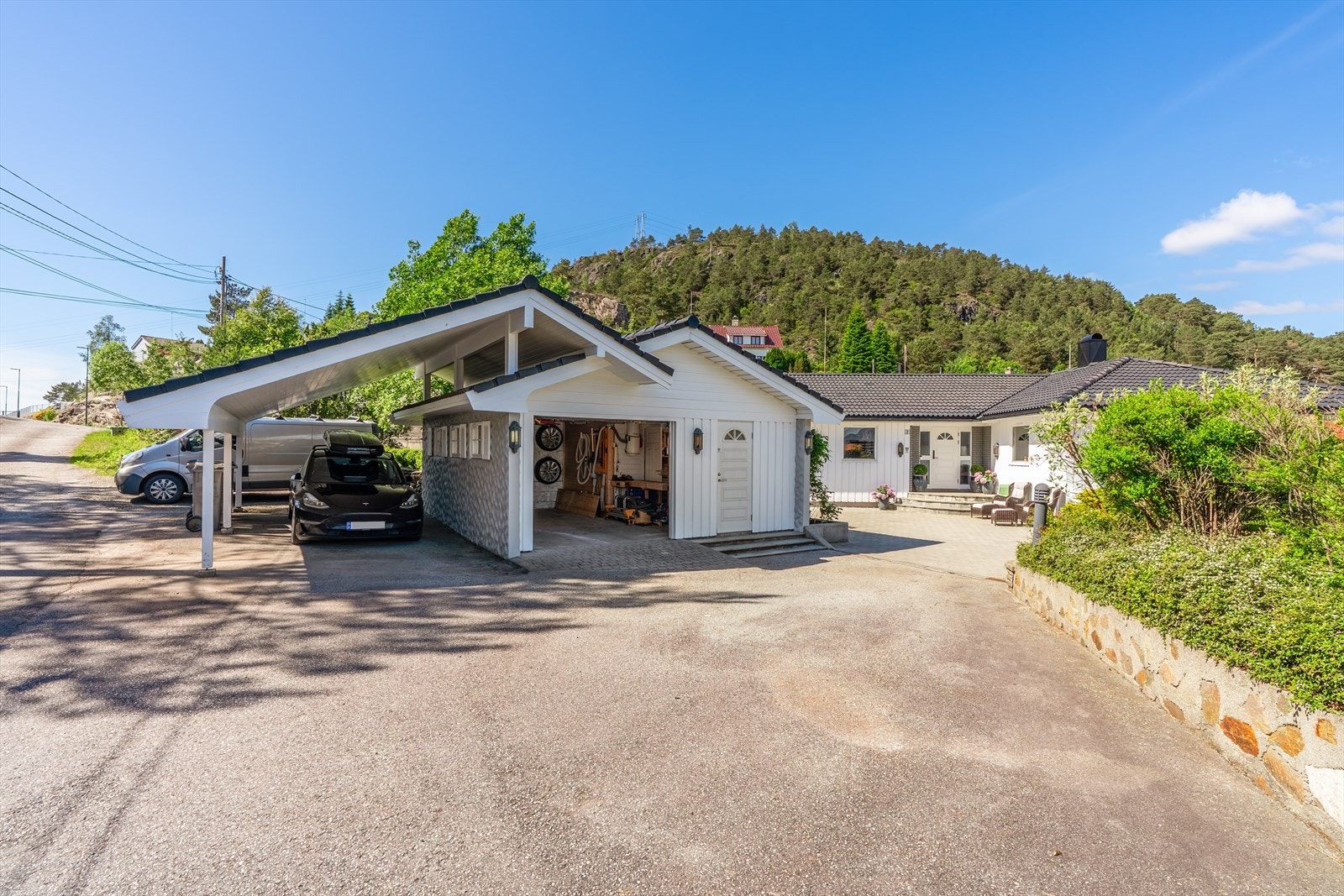 Her er det god plass til å parkere flere biler i både garasje, carport og ellers i innkjørselen. Galleribilde