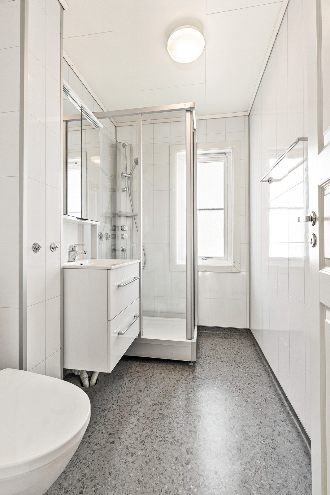 - Belegg på gulv, baderomsplater på vegg. Badet er innredet med toalett, dusjkabinett og innredning med servant - Galleribilde
