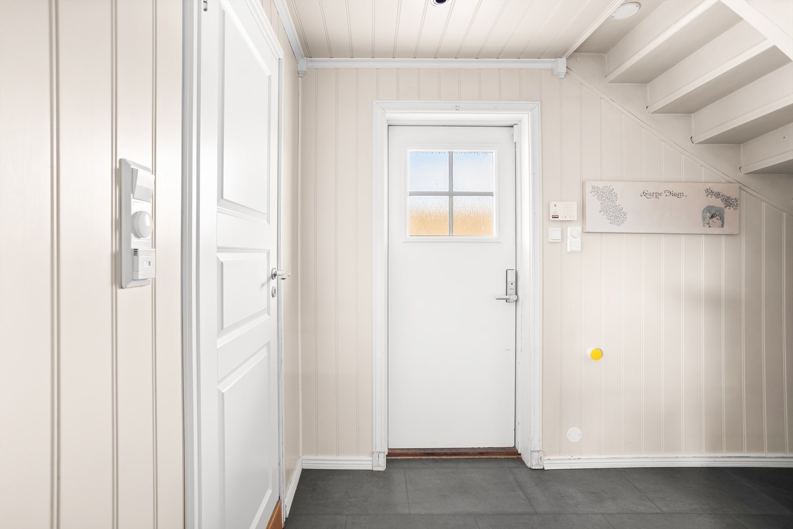 Inngangsparti med fabrikkmalt ytterdør og slitesterke fliser på gulvet. Galleribilde