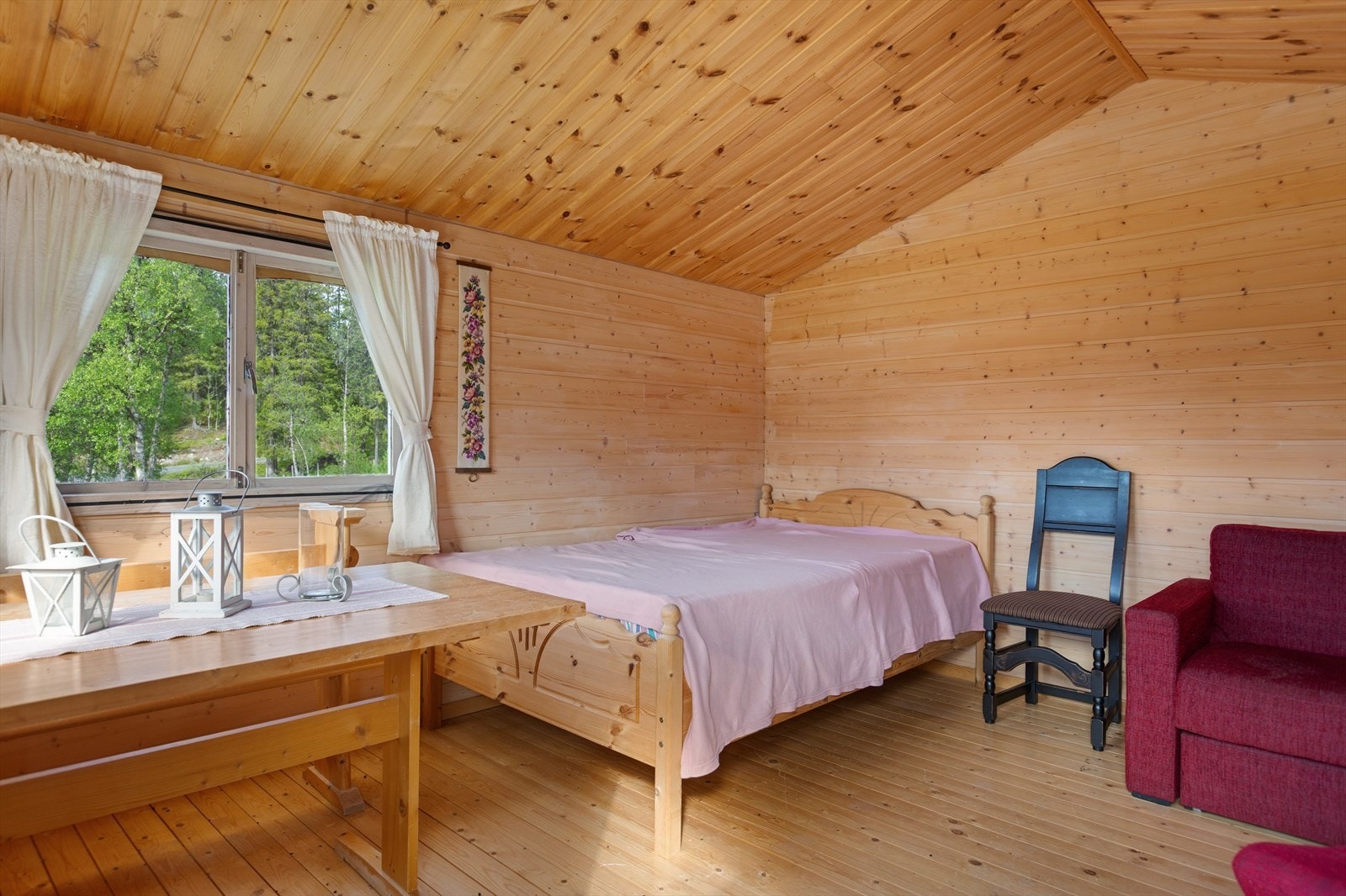 Inne i annekset er det åpent og luftig med mønet himling. Det er fin plass til både spisegruppe/sittegruppe og senger. Galleribilde