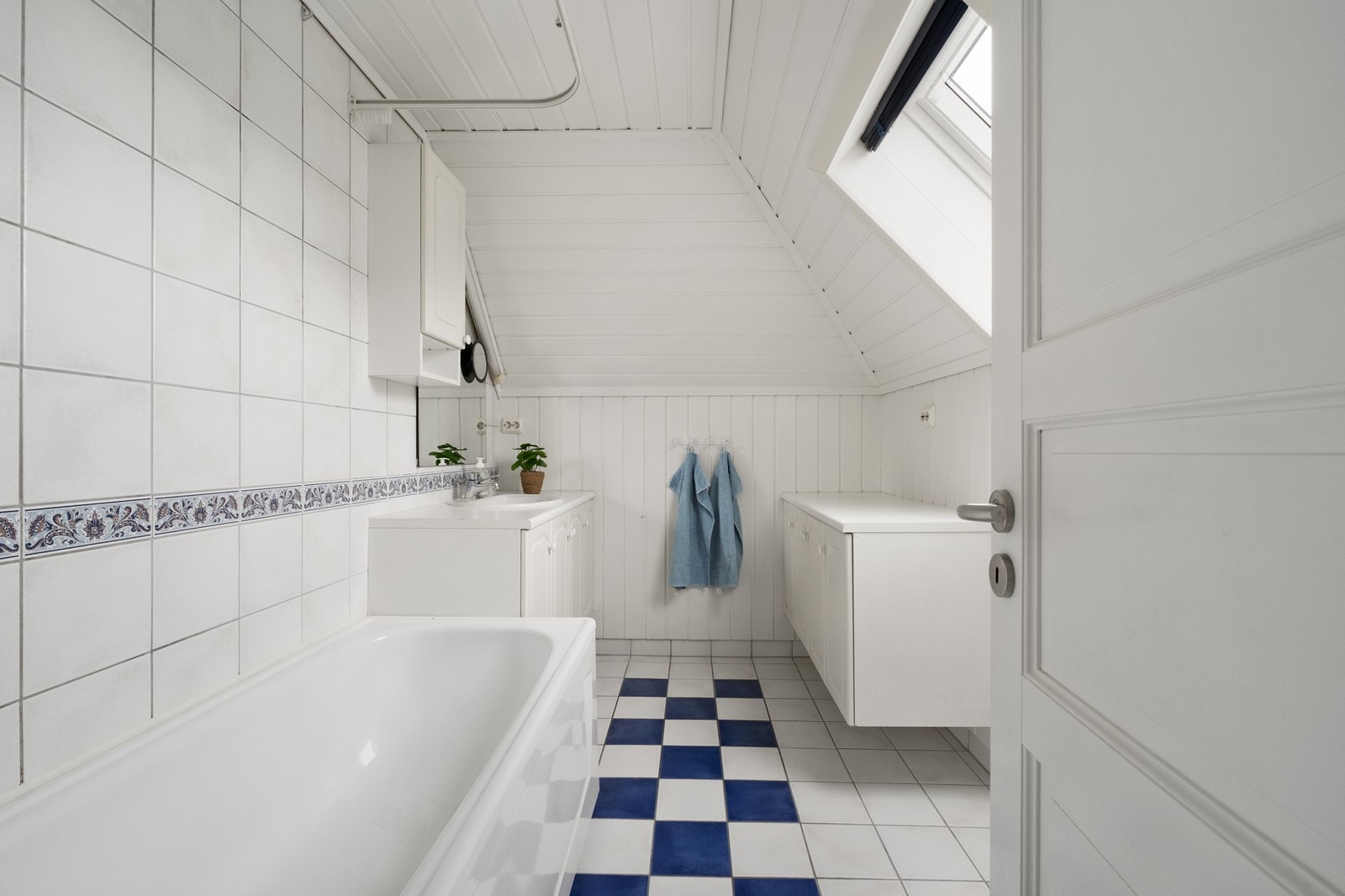 Hovedleilighet, loft: Badet er utstyrt med fliser på gulv og vegger, baderomsinnredning, badekar og takvindu for naturlig lys. Galleribilde