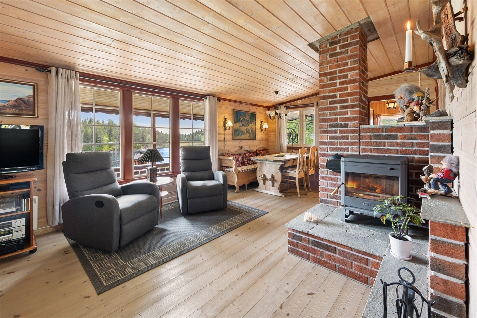 Stuen har en peisovn i en murt teglsteinsramme som gir god varme og hygge. Galleribilde
