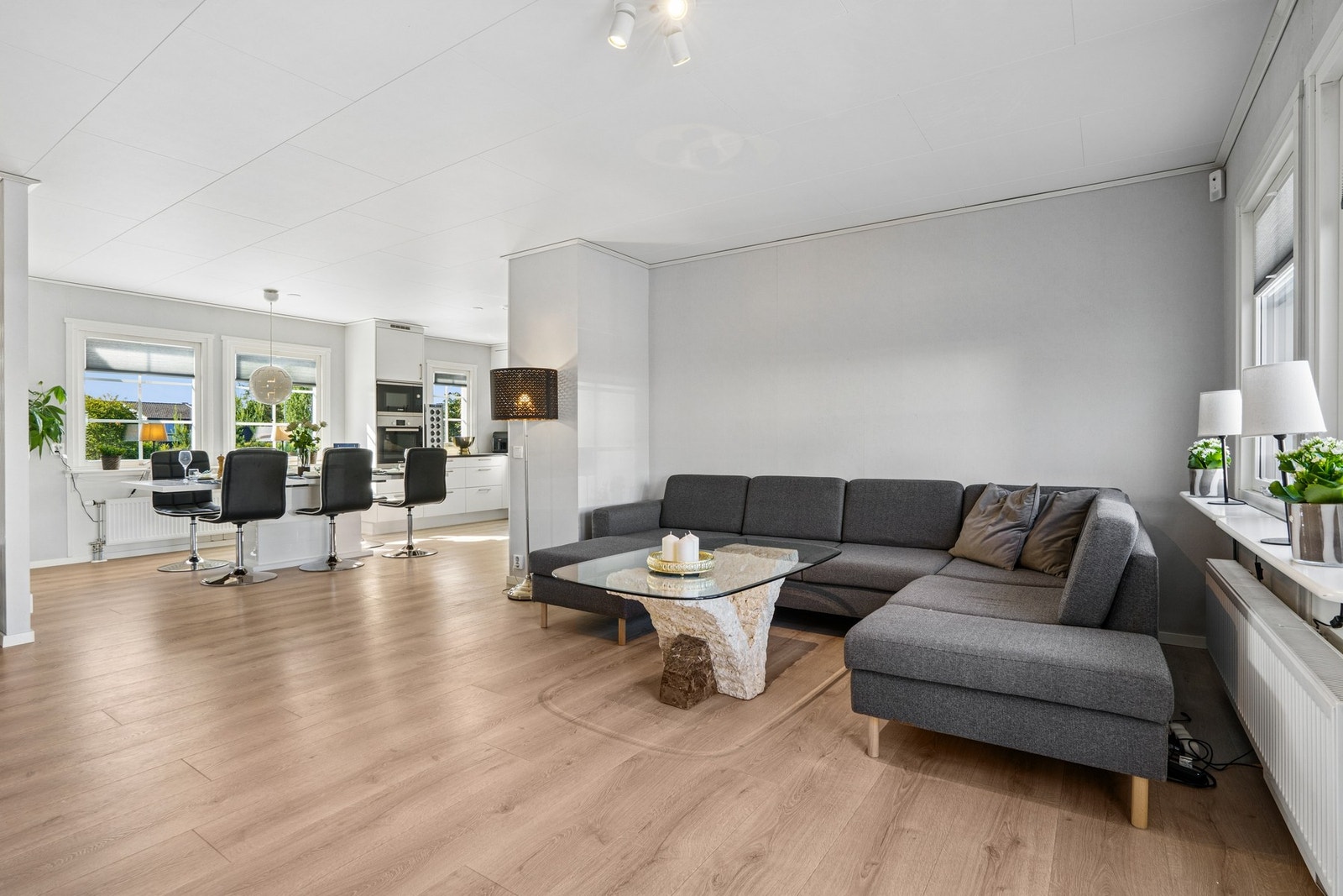 Boligens oppholdsrom består av en romslig stue i åpen løsning mot kjøkken og spiseplass. Store vindusflater sikrer godt lysinnslipp, mens peisovnen bidrar til en lun og hyggelig stemning året rundt. Galleribilde