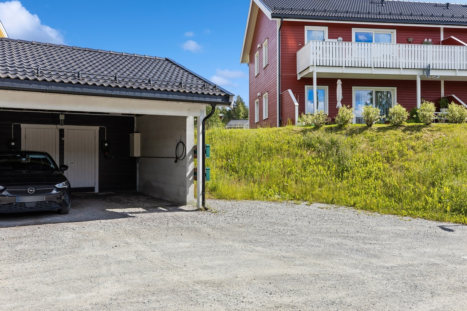 Til boligen hører en carport med tilhørende bod og installert elbillader. Galleribilde
