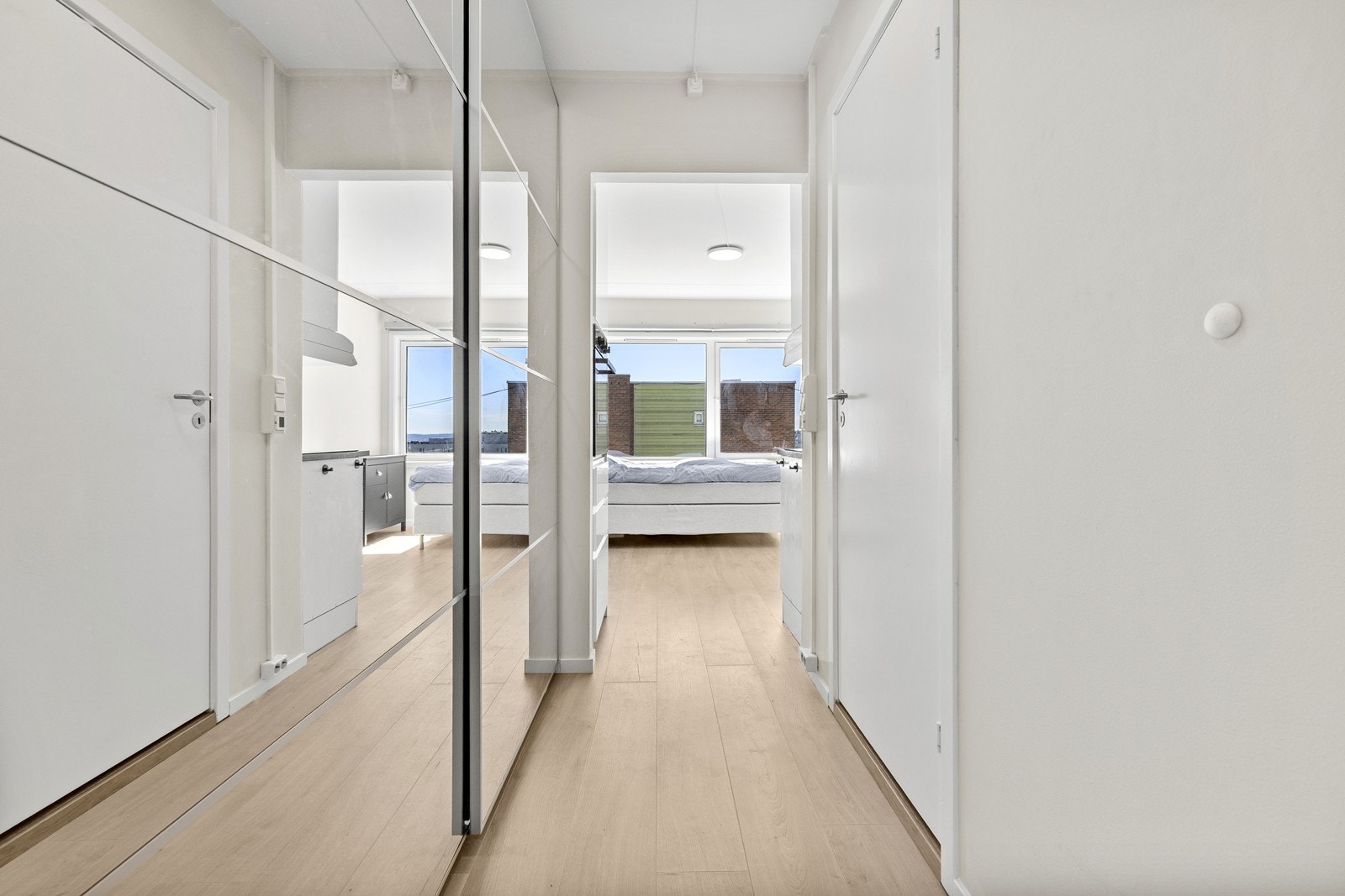 Skyvedørsgarderobe med speilfronter i entréen gir rikelig med oppbevaringsplass. Galleribilde