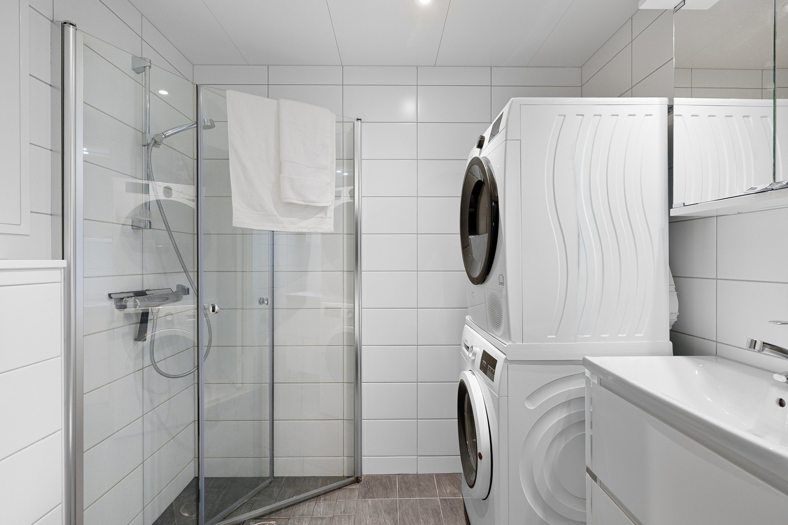 Lekkert, flislagt bad med opplegg for vaskemaskin. Galleribilde