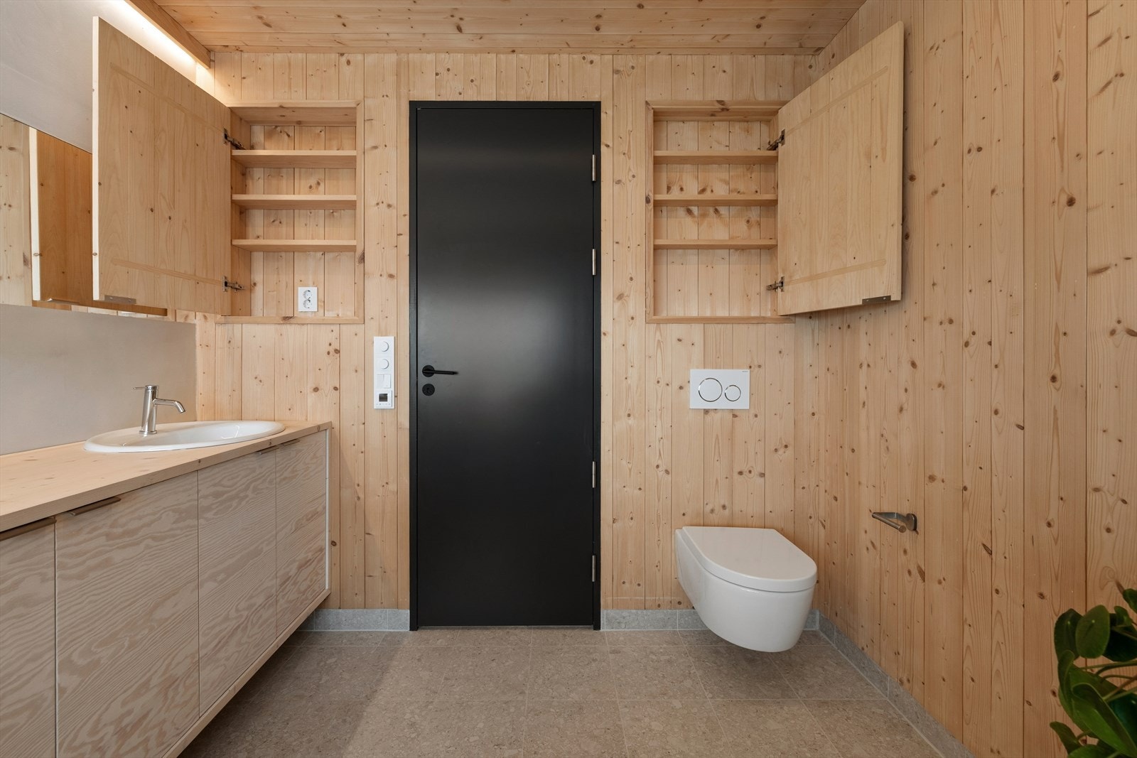 Badet har innfelte skap i veggen for smart oppbevaring, og vegghengt toalett. Galleribilde