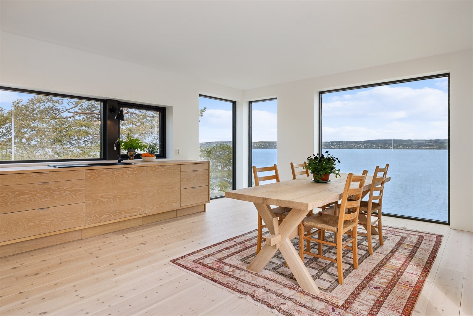 Kjøkkenet/allrommet har en storslått utsikt over fjorden. Legg merke til vinduene som går fra gulv til tak. Galleribilde