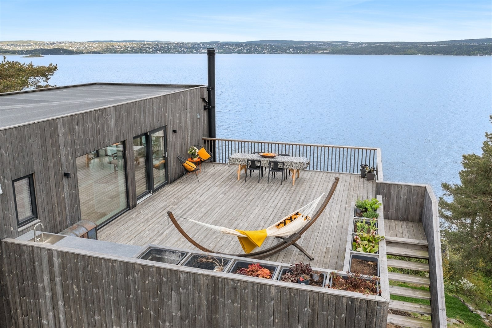 Den store takterrassen på 63 m2 har utekjøkken og plantekasser. Herfra er det vid utsikt fra Oslo til Svartskog. Galleribilde