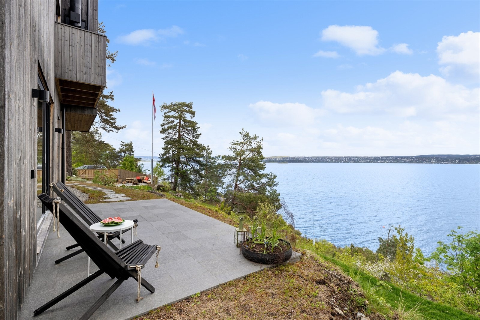 Fra stuedelen er det utgang til en østvendt, støpt terrasseplatting belagt med natursteinsfliser. Ingen innsyn og nydelig utsikt. Galleribilde