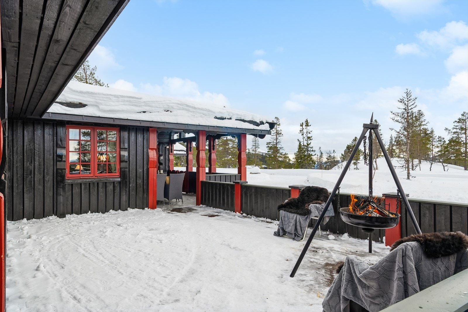 Overbygget terrasse med beiset impregnerte gulvbord og malt rekkverk gir et skjermet uteområde. Galleribilde