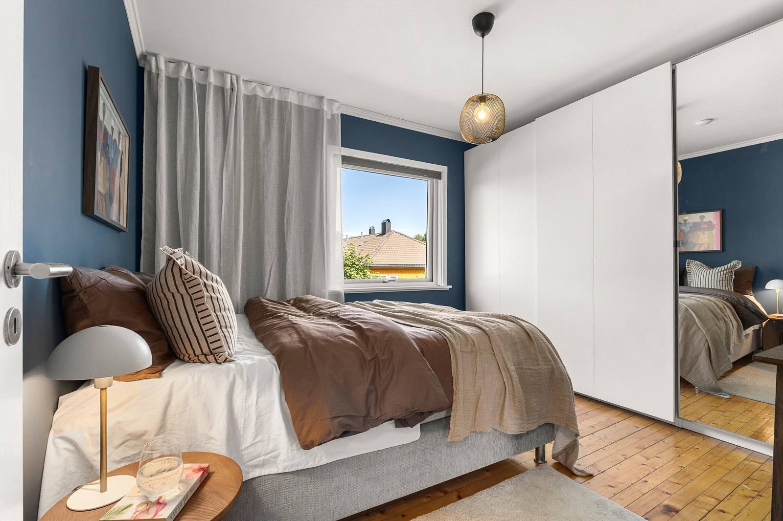 Langs den ene veggen på soverommet er det montert en romslig skyvedørsgarderobe som gir rikelig med oppbevaringsplass. Galleribilde