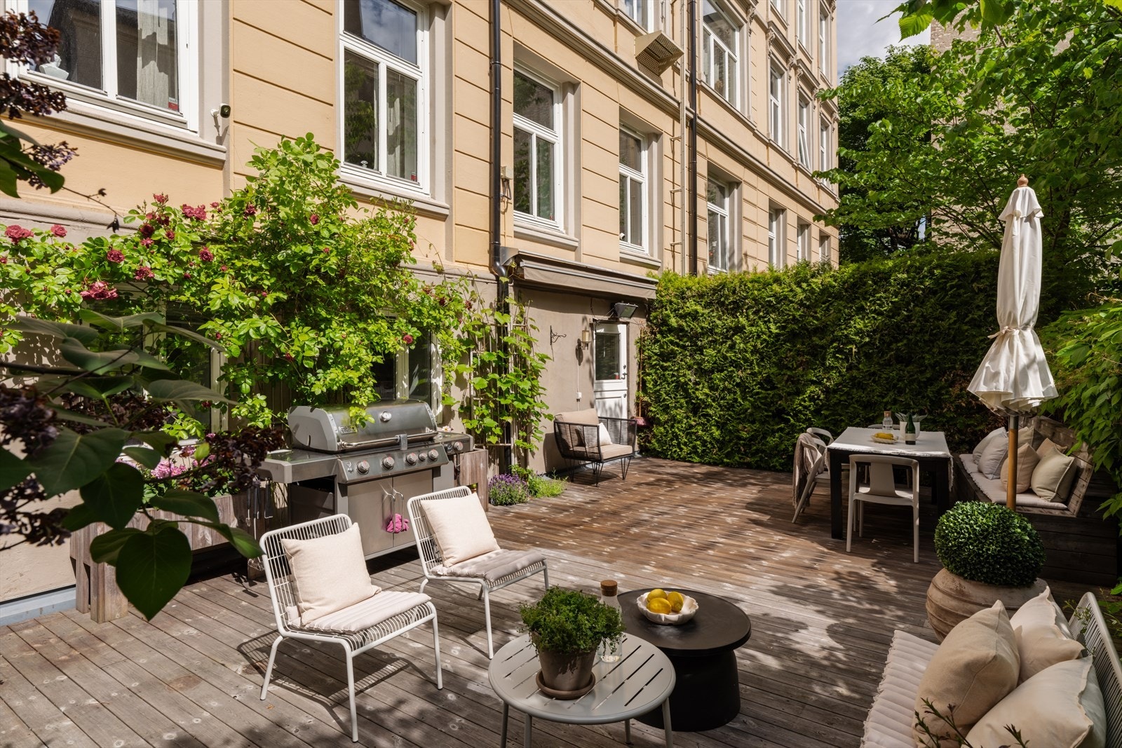 Terrassen fremstår som en grønn oase med flotte beplantninger bestående av hekker, syriner, klatreroser og vindruer som skaper en lun og skjermet atmosfære. Galleribilde