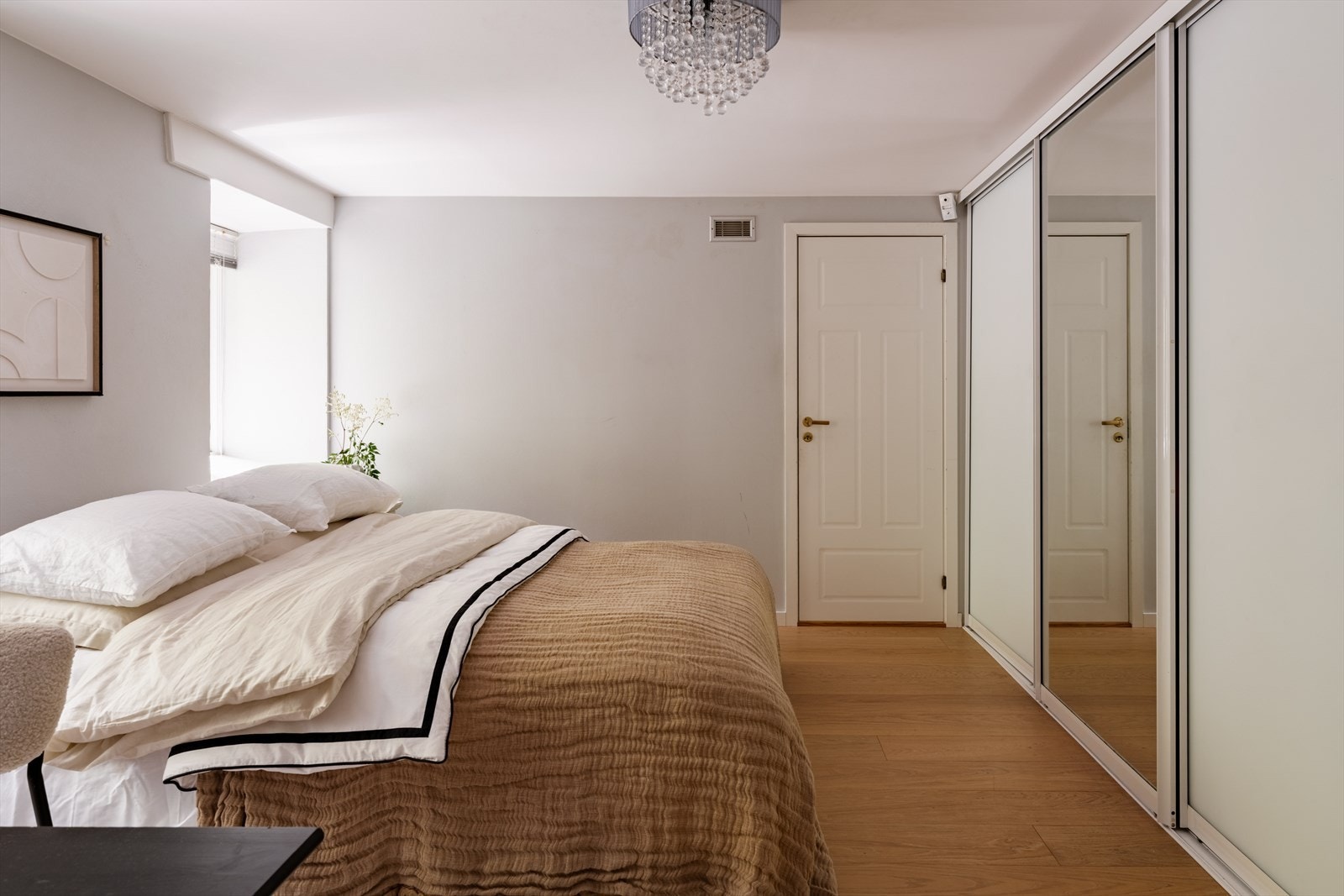 En stor skyvedørsgarderobe strekker seg langs den ene veggen og gir rikelig med oppbevaringsplass, mens boligens innvendige bod er praktisk tilknyttet rommet. Galleribilde