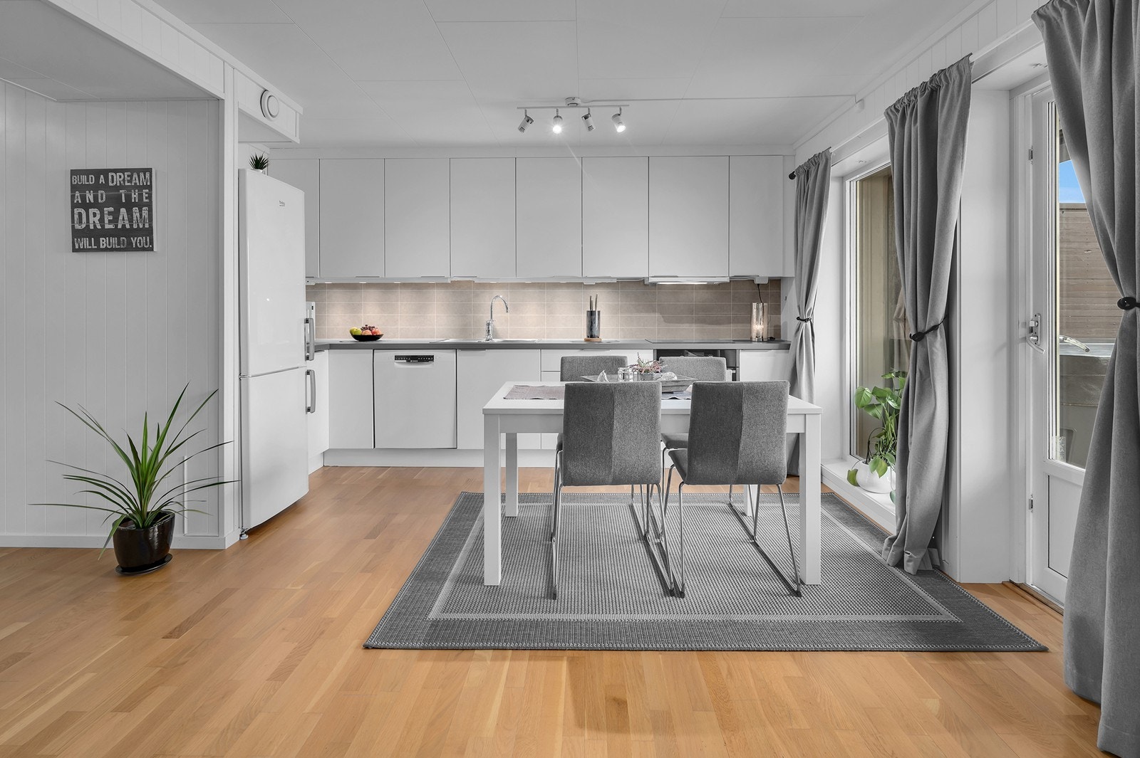 Kjøkkenet har en tidløs innredning med glatte fronter og laminert benkeplate Galleribilde