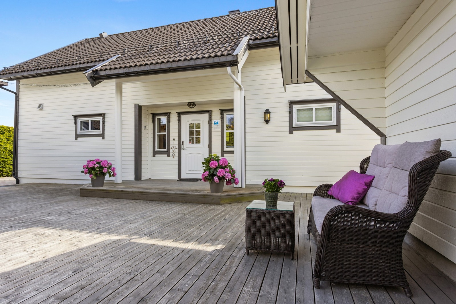 Den store terrassen strekker seg rundt deler av boligen og gir god plass til utemøbler, grill og hyggelige sommerdager. Galleribilde
