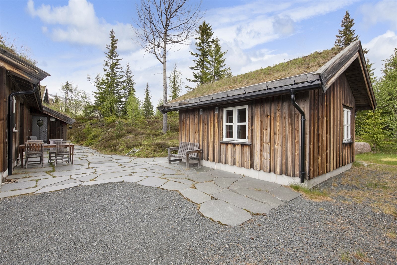Tunet er hjertet i eiendommen, et naturlig samlingspunkt mellom de to byggene. Skiferen gir et solid og tidløst uttrykk, og den solrike plasseringen gjør at det blir brukt fra tidlig vår til sen høst. Galleribilde