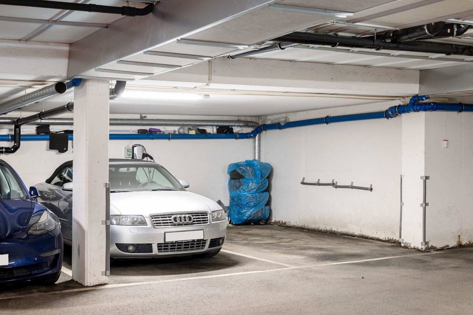 Med boligen følger fast parkeringsplass (til høyre i bilde) og en bod på 5 m² i felles, underjordisk garasjeanlegg. Mulighet for kjøp av garasjeplass (til venstre i bilde) Galleribilde