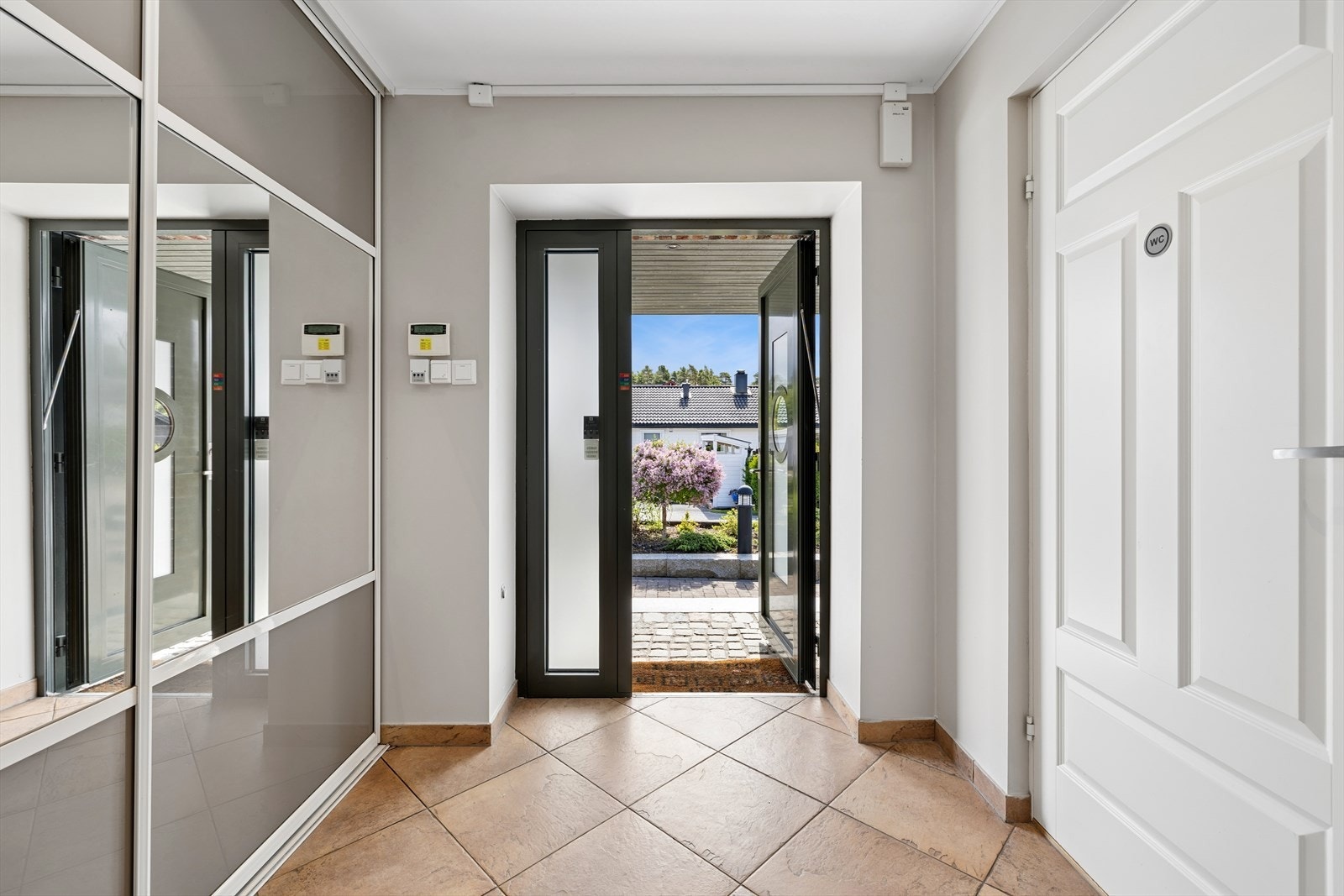 Aluminiumsdøren med fingeravtrykkslås åpner inn til en romslig entré med skyvedørsgarderobe. Galleribilde
