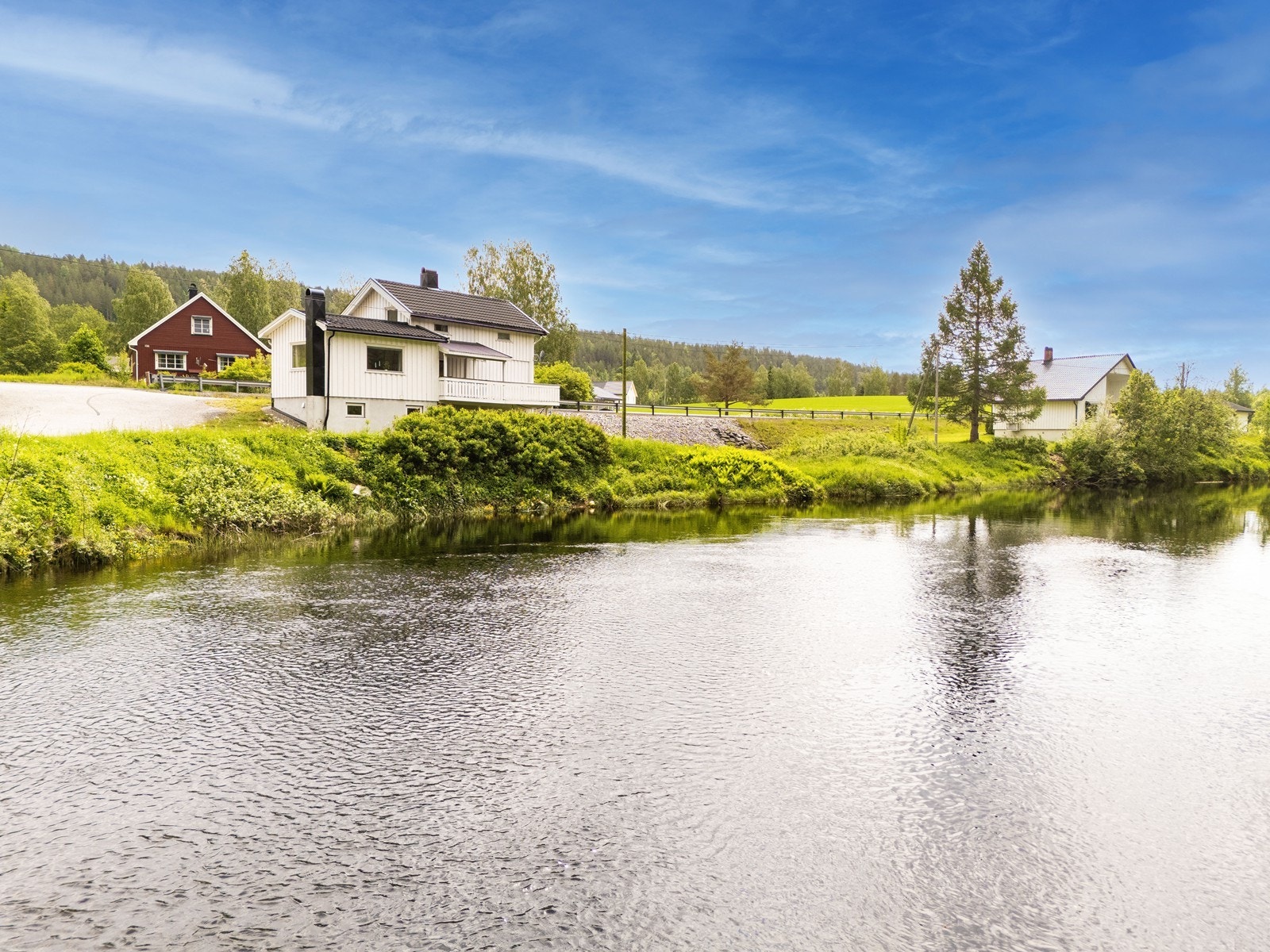 Boligen har en idyllisk plassering helt nede ved elveløpet. Galleribilde