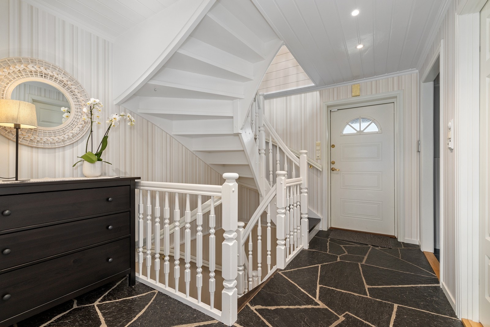 Velkommen inn i en romslig entré. Den malte tretrappen binder etasjene sammen. Galleribilde