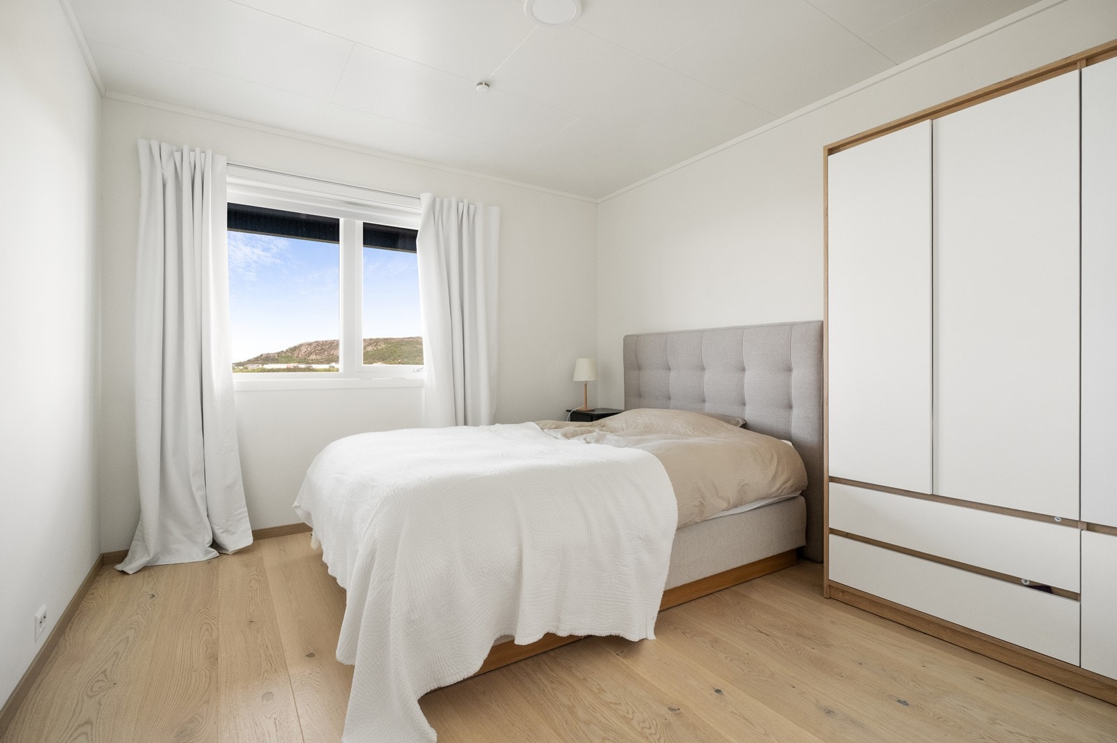 Soverom med plass til dobbeltseng og garderobe. Vindu med utsikt mot Kvernberget Galleribilde