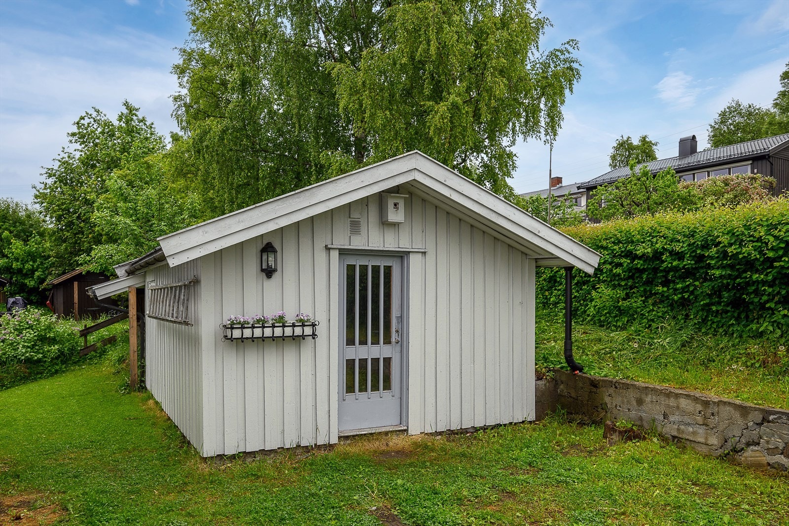 Frittstående uthus fra 1995 på 18 m² gir ekstra lagringsplass. Galleribilde