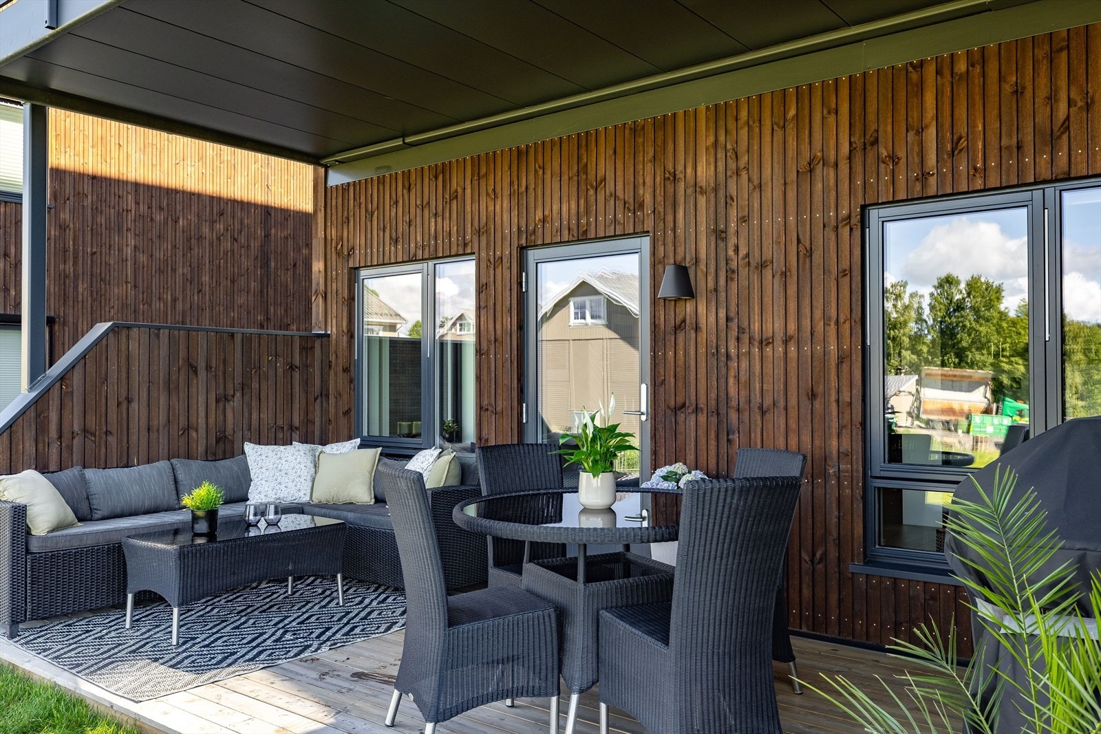 Terrassen er overbygget, har terrassebord på gulv og levegger i begge ender. Det er også montert utebelysning. Galleribilde