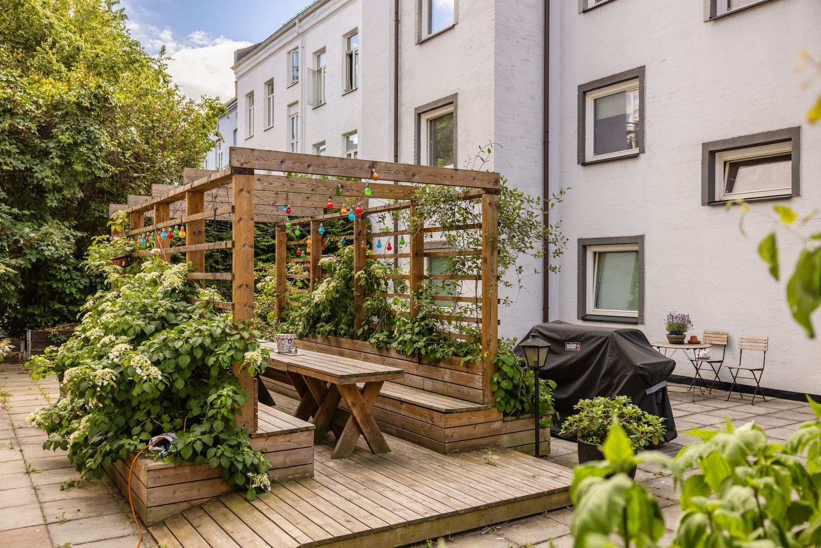 I bakgården er det en superkoselig uteplass sittebenker, bord og pergola med frodig beplantning. Galleribilde