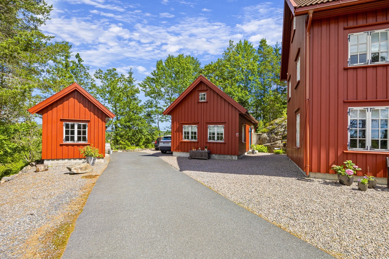 Asfaltert adkomstvei fører opp til boligen, verkstedet og redskapsboden. Galleribilde