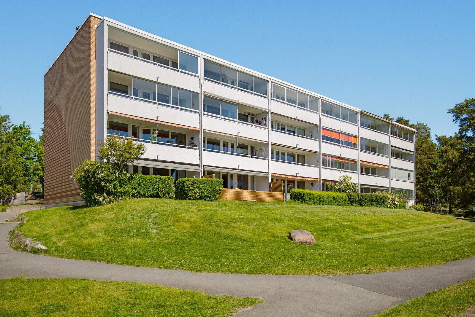 Sørvendt fasade med balkonger og uteplasser som vender mot fellesarealene. Galleribilde