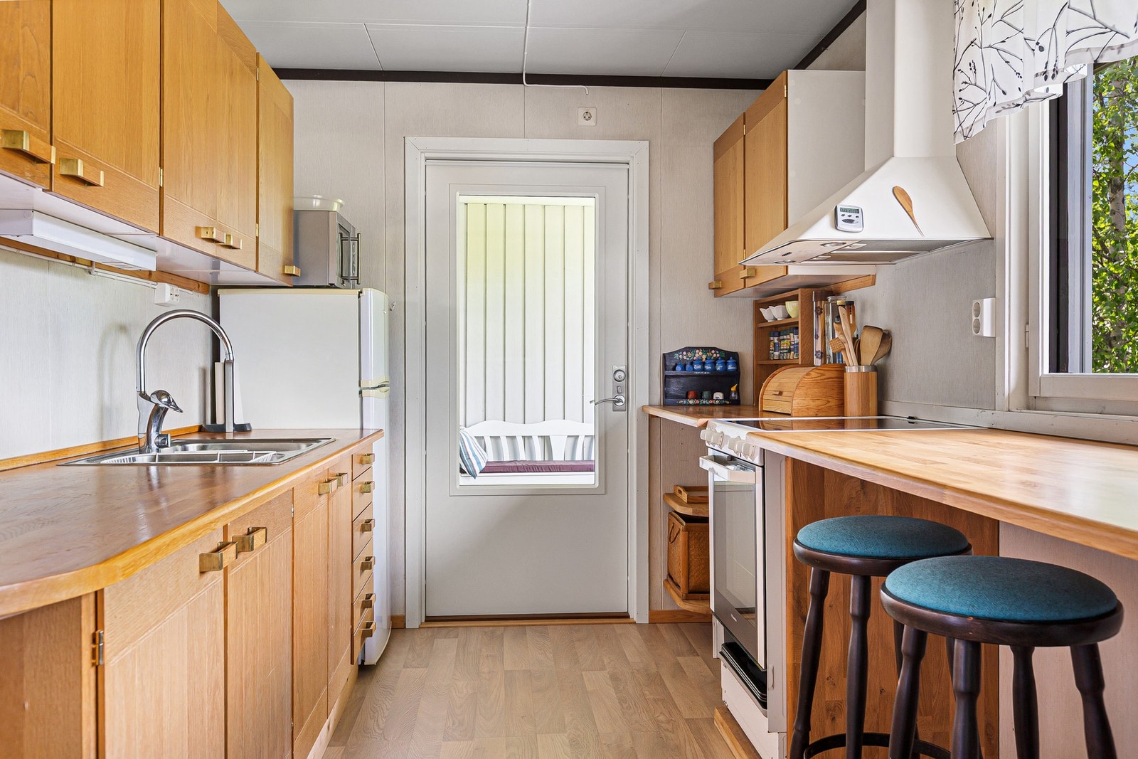 Kjøkkeninnredningen er i folierte plater, med et underskap i heltre og fronter i plater med eikebelegg, og heltre benkeplate i eik. Galleribilde