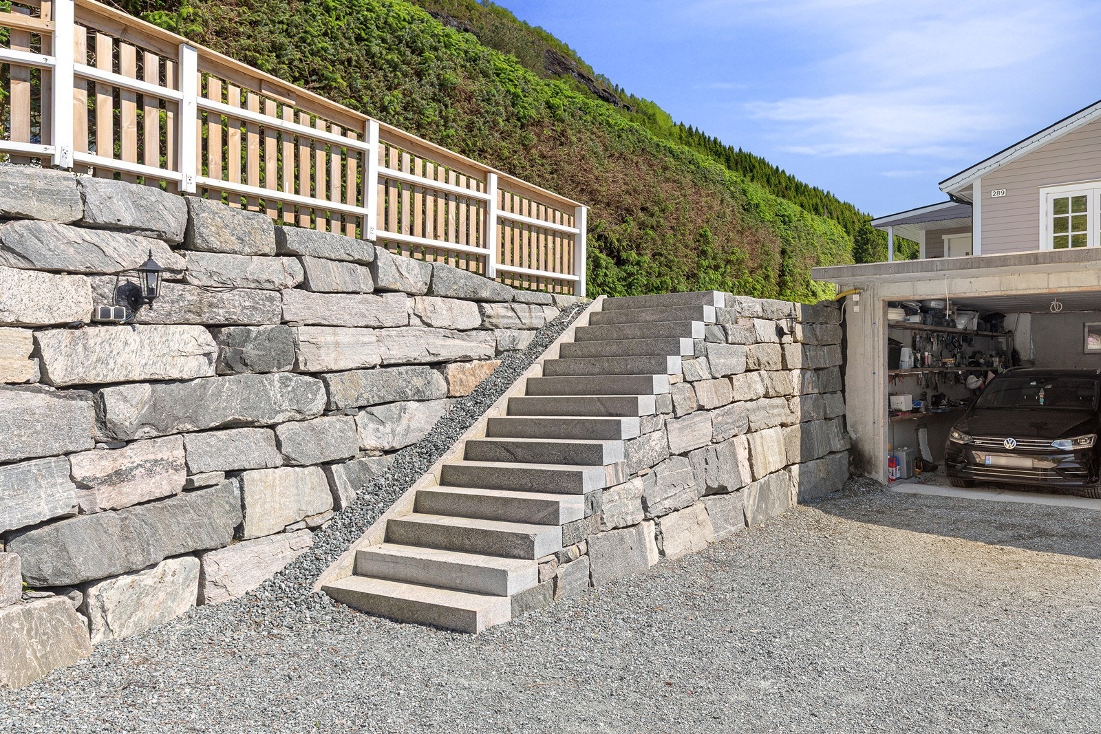 Pent opparbeidd uteområde med solide natursteinsmurar, steintrapp og tilkomst til garasje Galleribilde