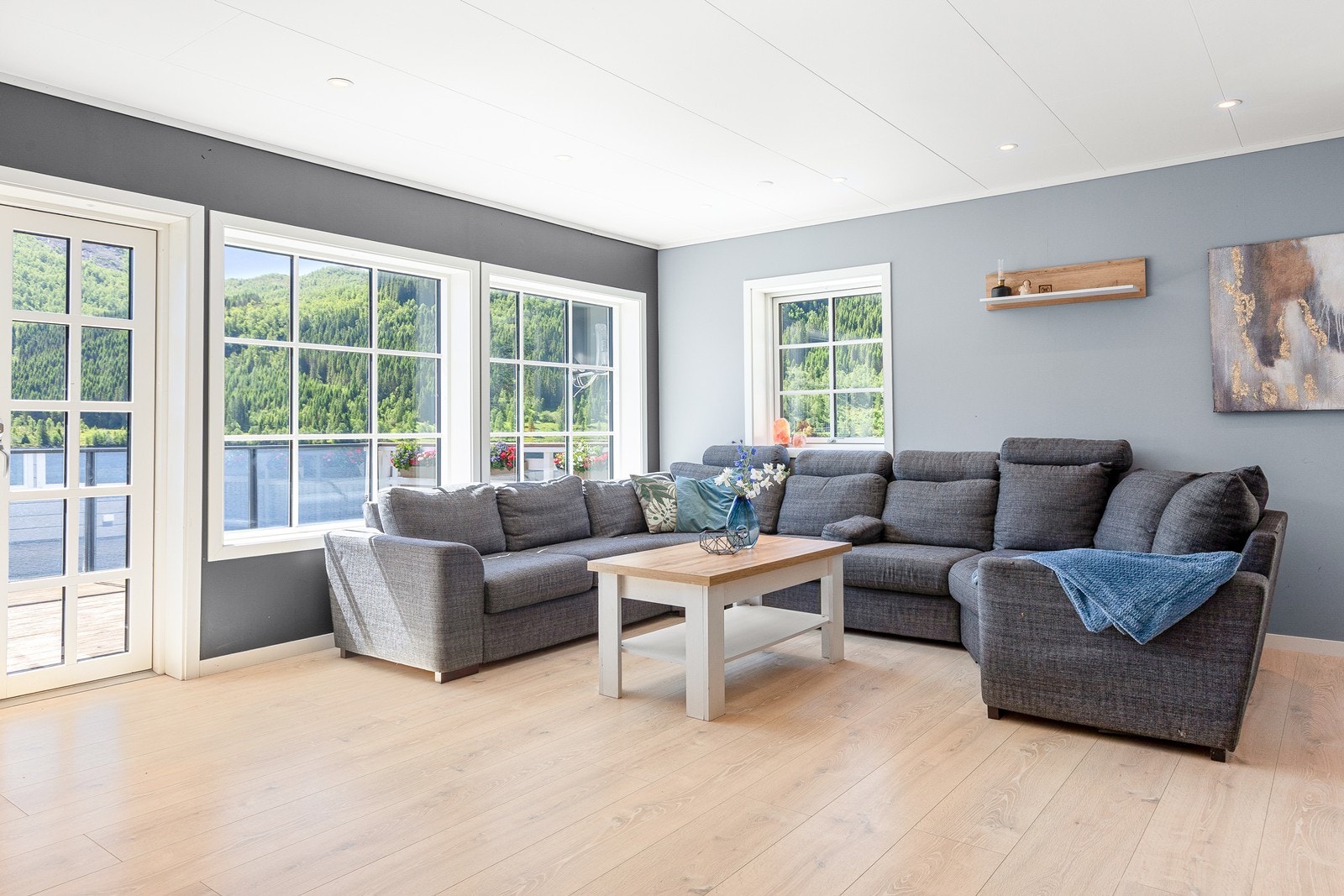 Store vindaugsflater slepper inn rikeleg med naturleg lys i stova Galleribilde