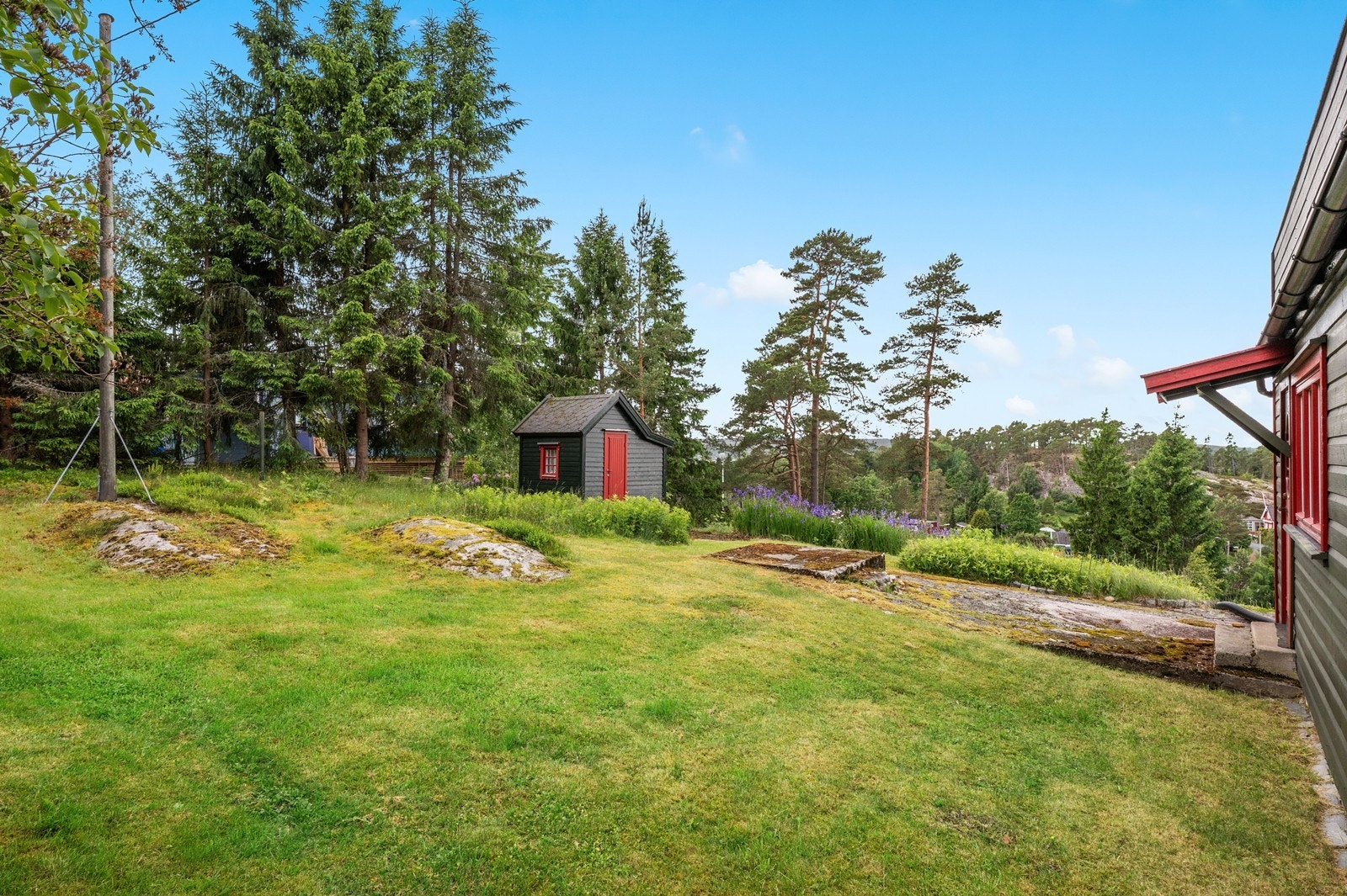 Tomten består av plenarealer og naturlig terreng. Galleribilde