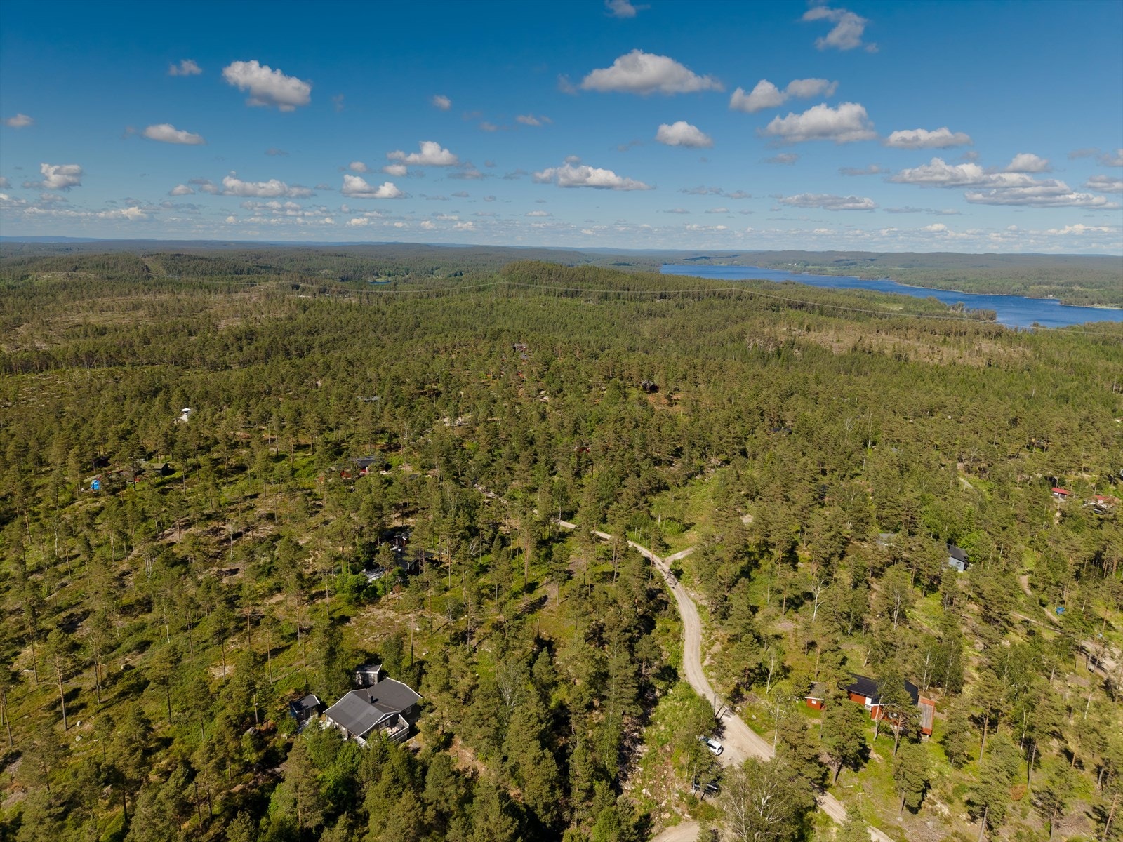 Hytta (nede til venstre) med omkringliggende hytter og natur. Galleribilde