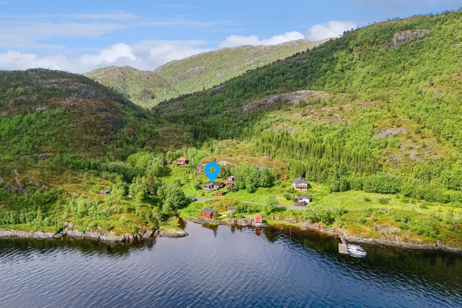 Dronebilde som viser eiendommens plassering med nærhet til sjøen. Galleribilde