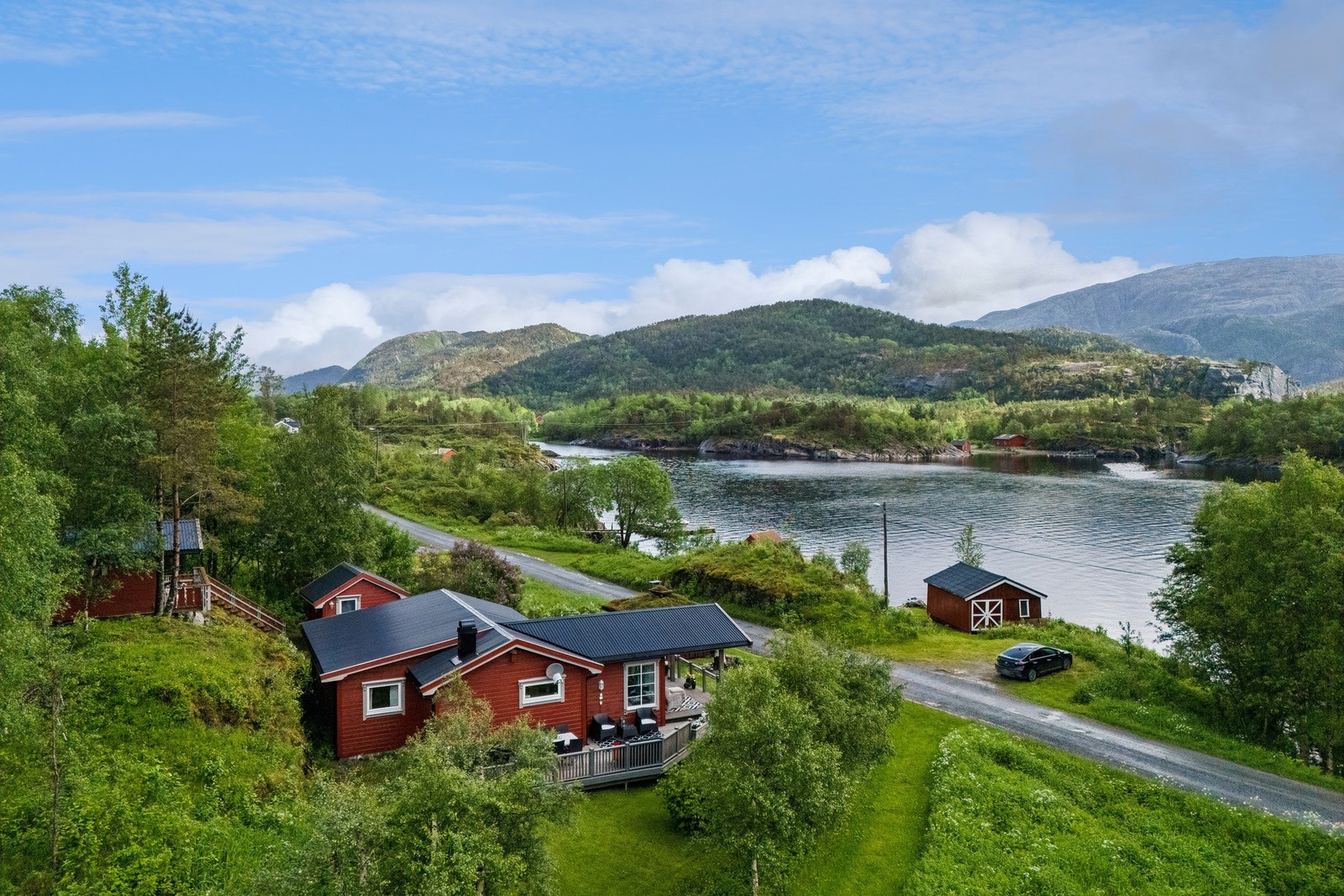 Eiendommen sett fra luften, med hovedhytte, anneks og grillbu. Galleribilde