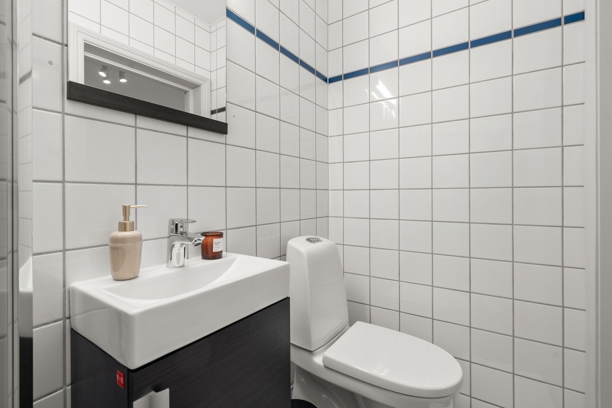 Badet er utstyrt med toalett, servant og dusj Galleribilde