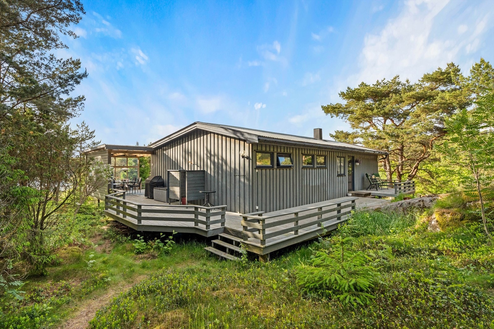 Hovedbygningen er omgitt av naturtomt med svaberg og furutrær. Galleribilde
